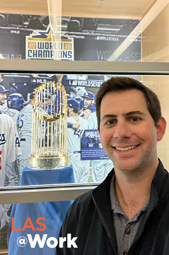 Man posing next to 2020 LA Dodgers World Series trophy