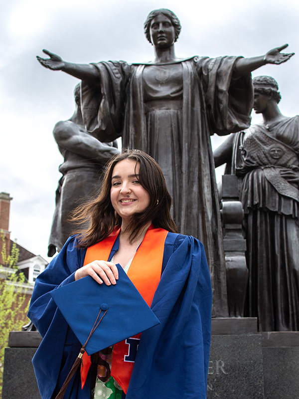 Smiling young woman in graduation robe 