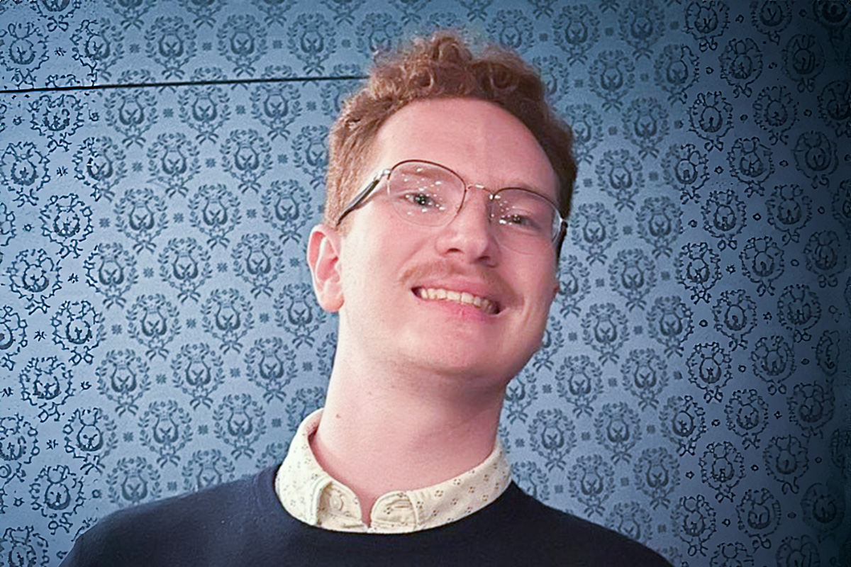 Smiling young man in glasses, sweater and collared shirt