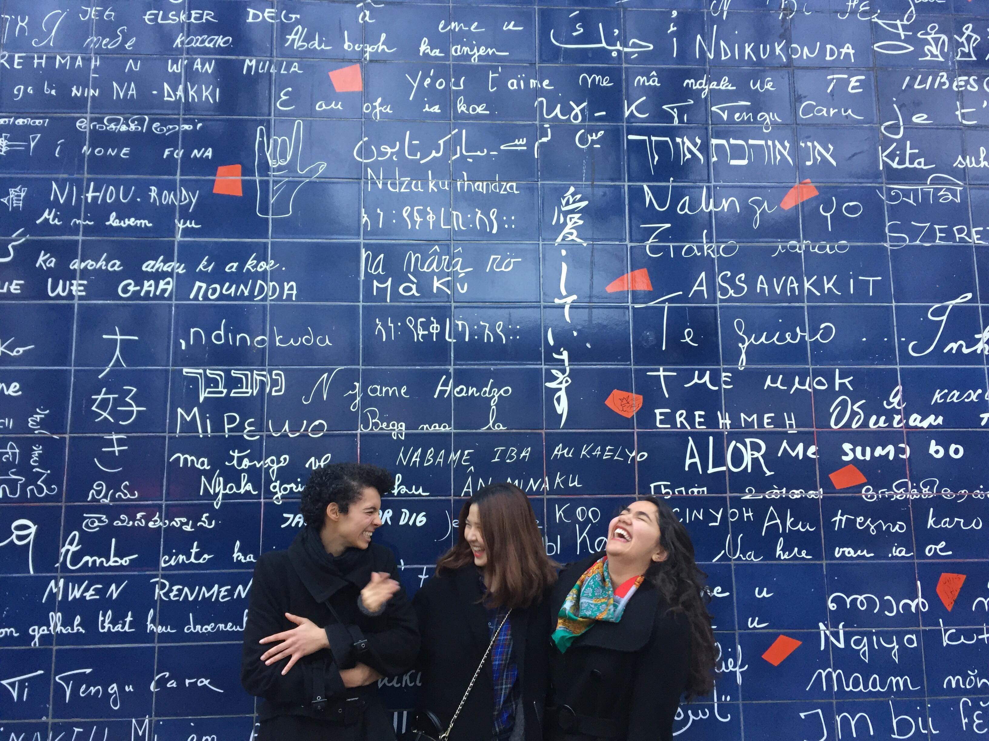 Students standing in front of wall with writing in Paris