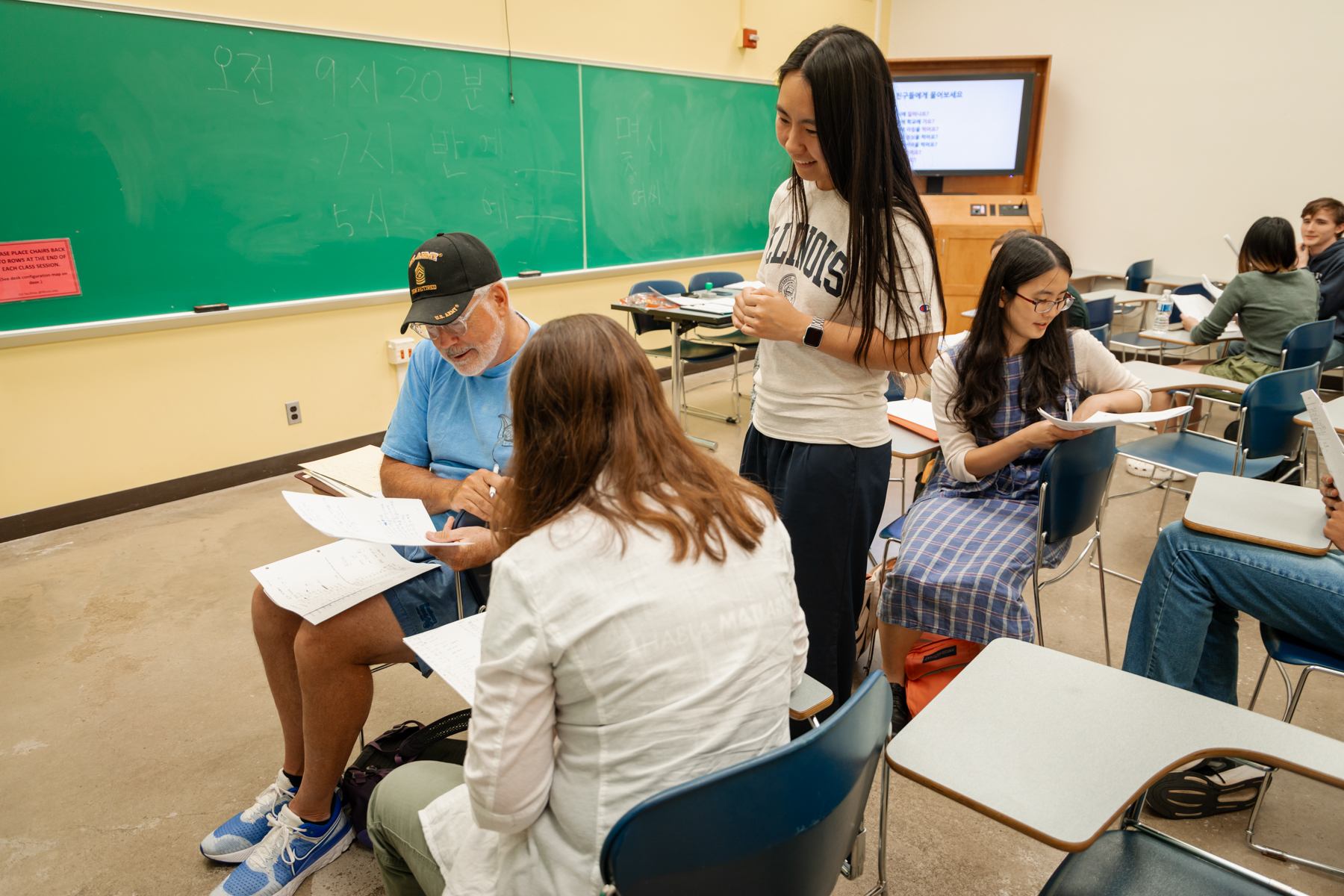 ILIP instructor stands among desks advising students