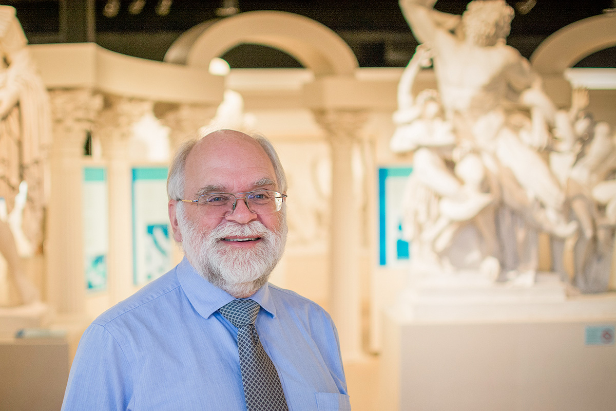 Smiling man in glasses with white hair and beard in Spurlock Museum