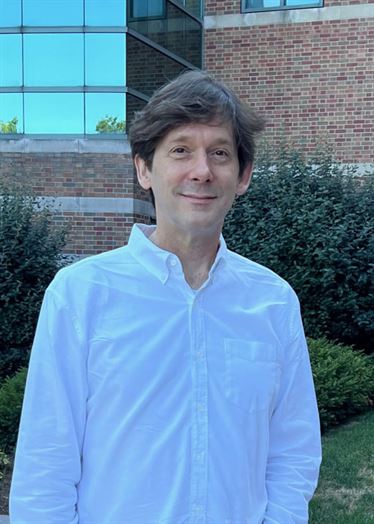 Dark haired man in white button-up shirt