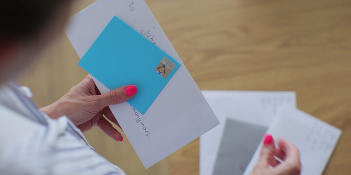 woman checking mail holding envelopes