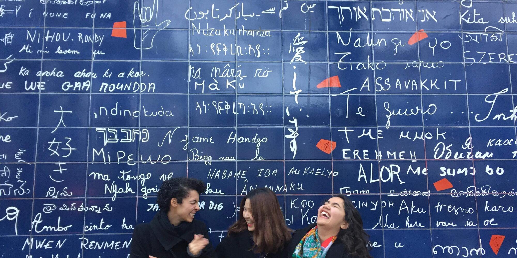 Group of students laughing in front of mural in Paris