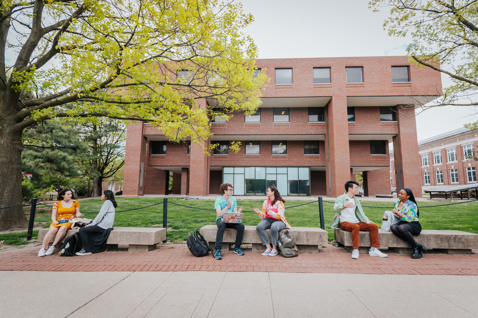 Students posing on benches outside Literatures, Cultures & Linguistics Building