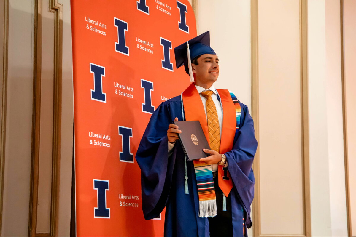Student at convocation holding degree