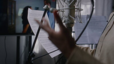 Voice actress in headphones holding cue sheet