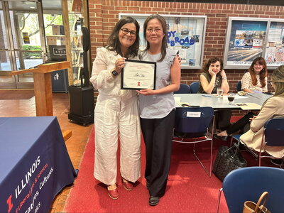 Smiling women hold up award