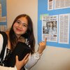 Flor Quiroz poses next to clipping of her News Gazette article