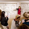Classics professor in red dress giving lecture at Spurlock Museum