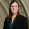 Headshot of woman in black blazer and dark shirt