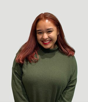Smiling young redheaded woman in green sweater