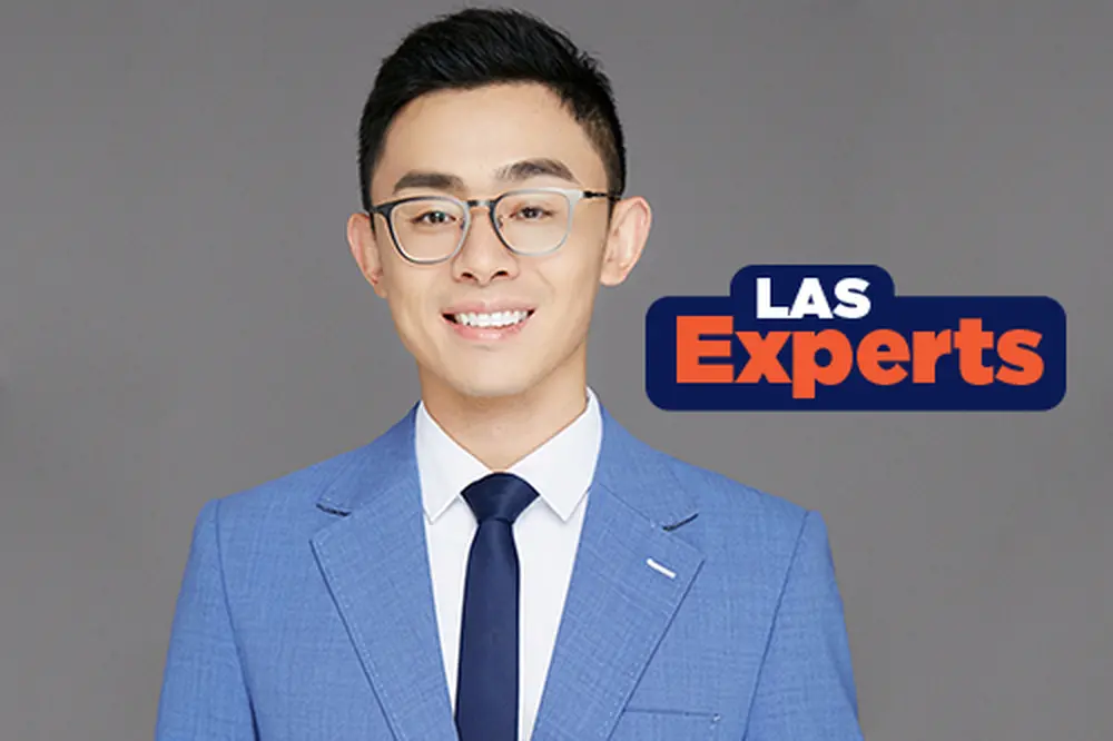 Xun Yan Photo of a smiling, dark-haired man in glasses and a blue suit.