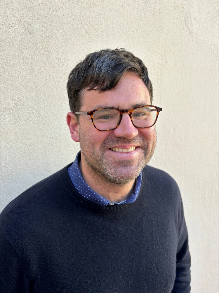Man in dark sweater and glasses