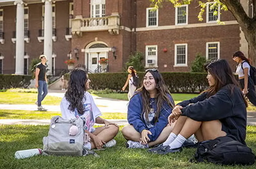 Three students sit on Quad