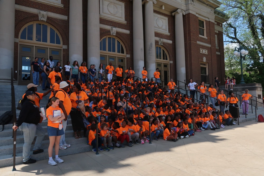 Large group of children in matching bright orange t-shirts