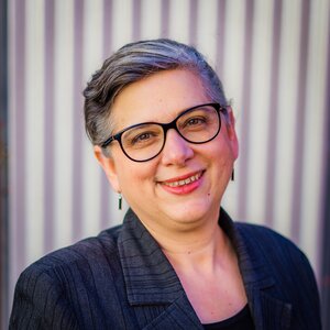 Woman with glasses smiles at camera