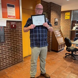 Man poses with award