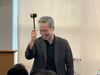 Smiling man holds up gavel 