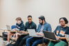 Four students sitting with laptops in a French classroom