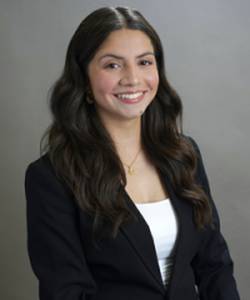 Dark-haired young woman smiles and poses for headshot